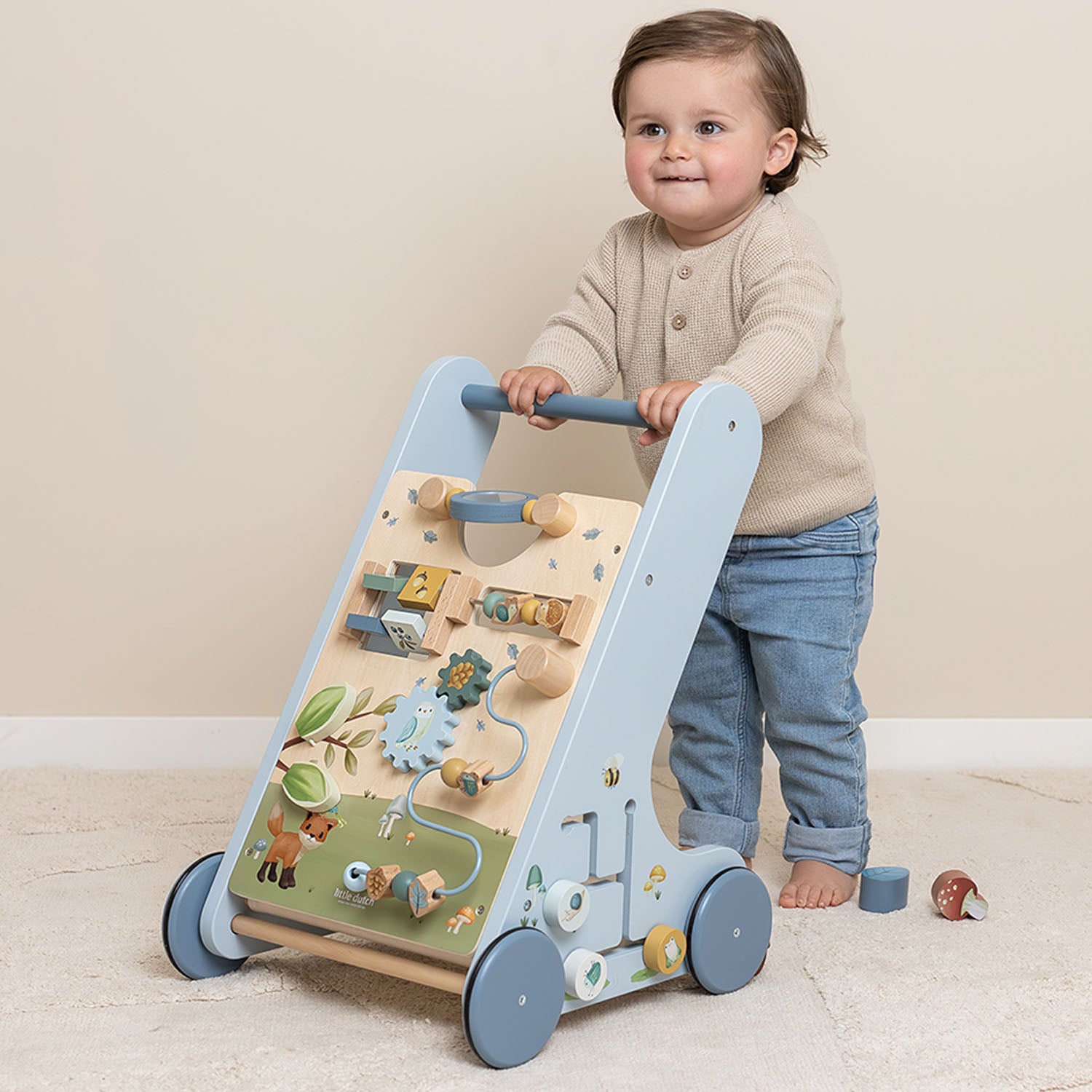A toddler is playing with the little dutch baby walker.