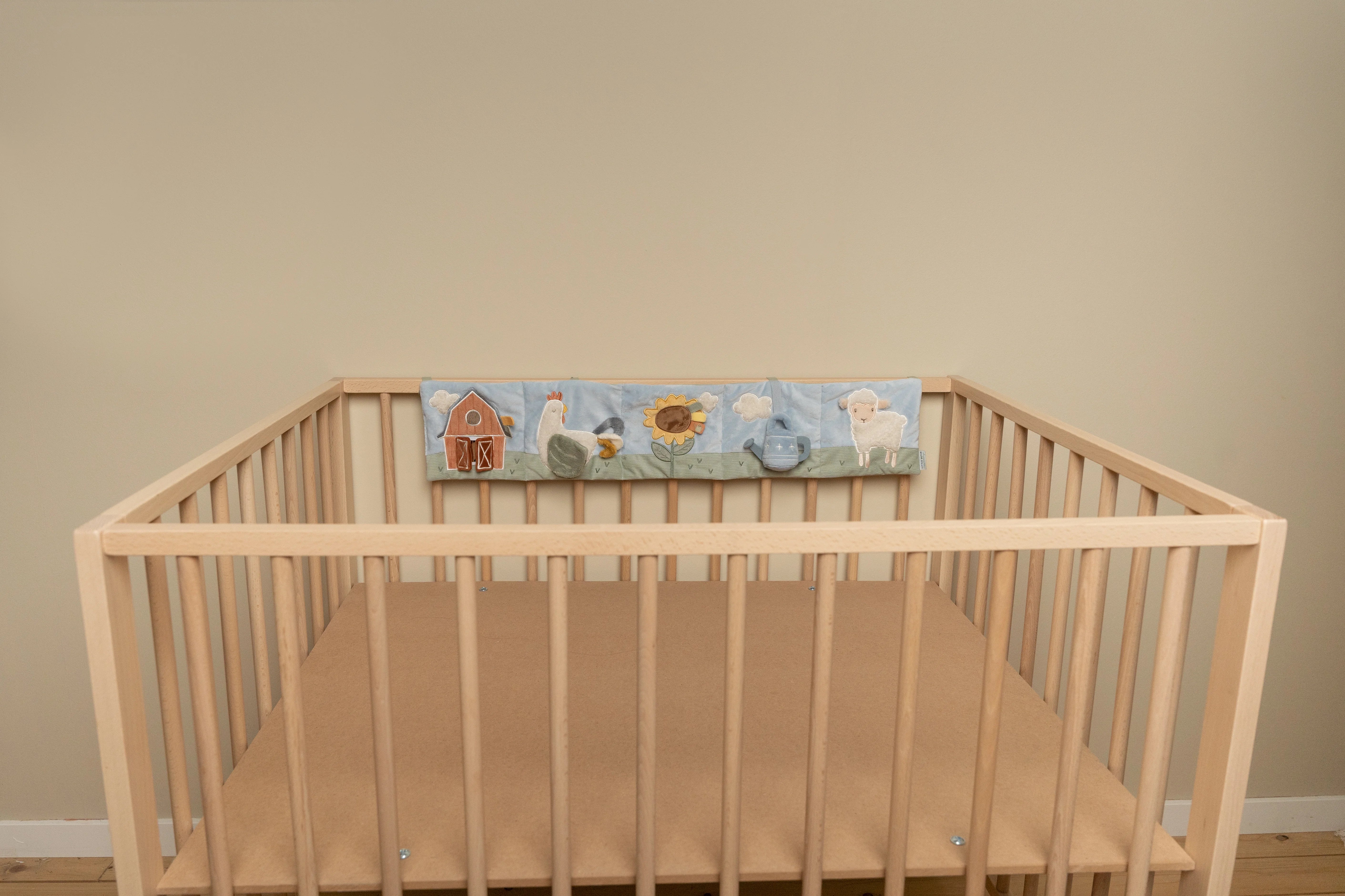 Little dutch playpen activity book hanger hanging on the crib.