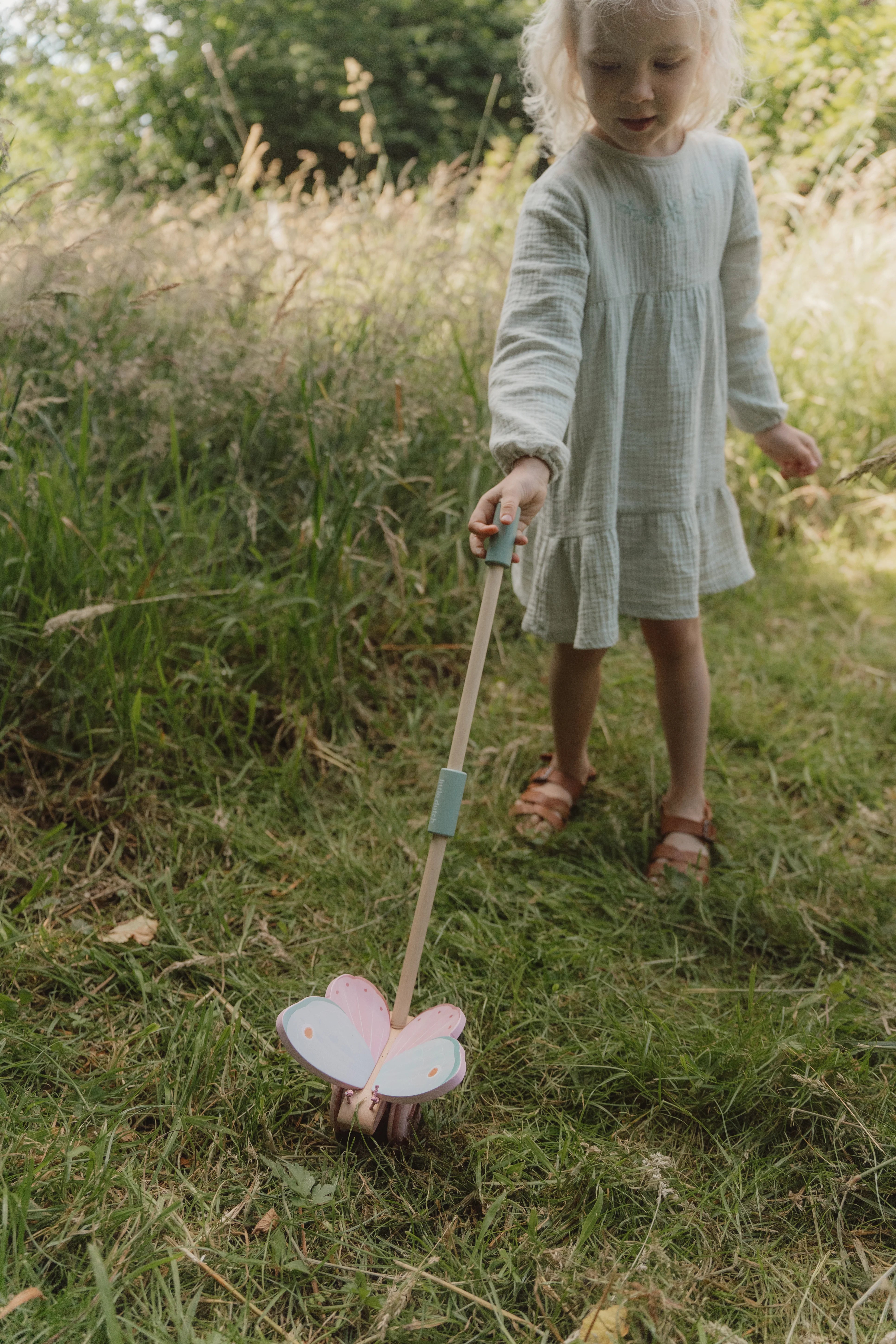 Toddler playing with little dutch push-along butterfly.