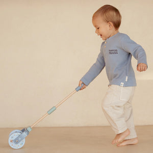 A toddler is playing with Little Dutch rattle