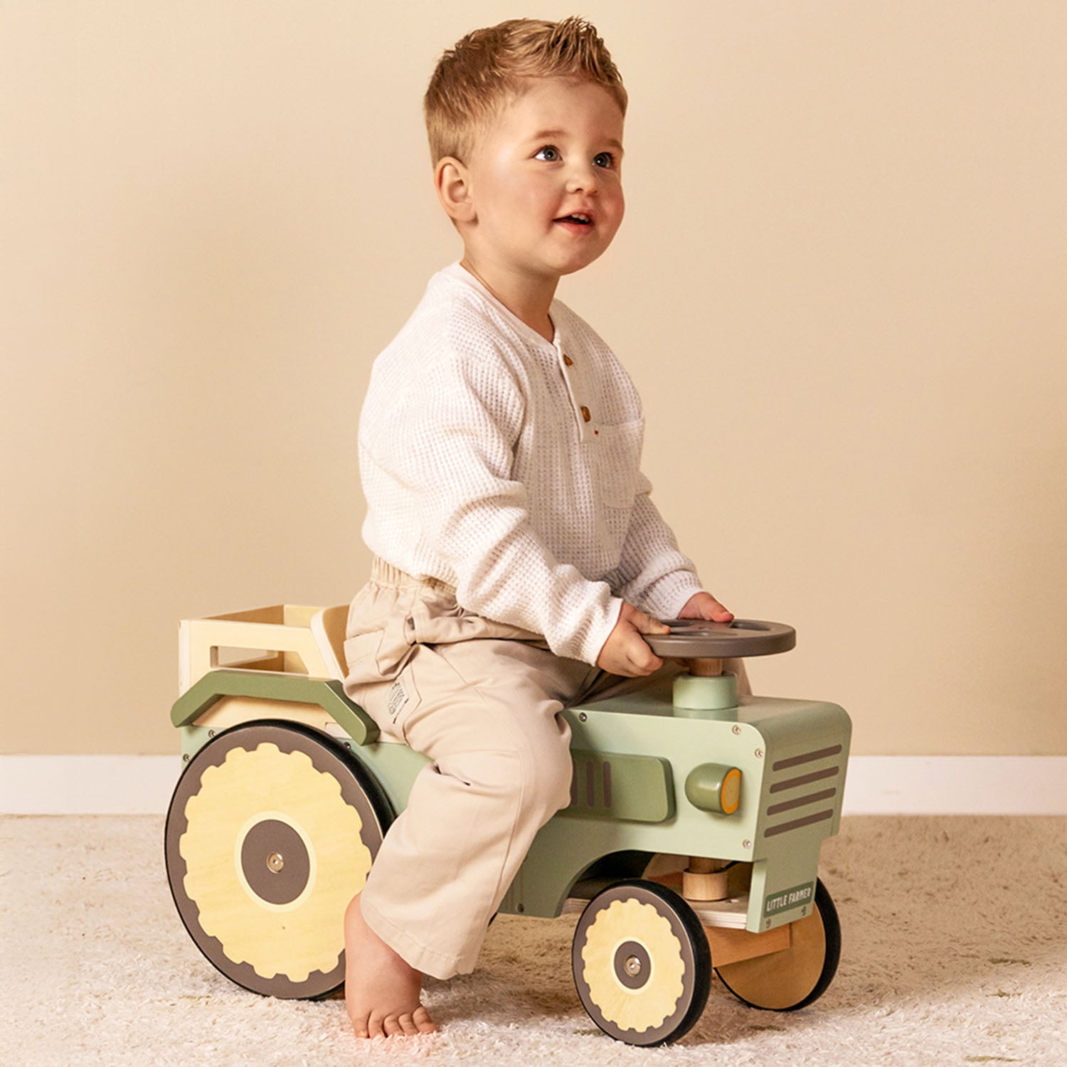 Child riding Little Dutch tractor indoors.