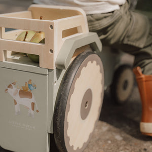 Little Dutch ride-on tractor with toy box at the back.