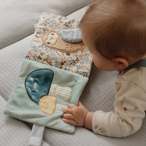 Baby is playing with the soft activity book