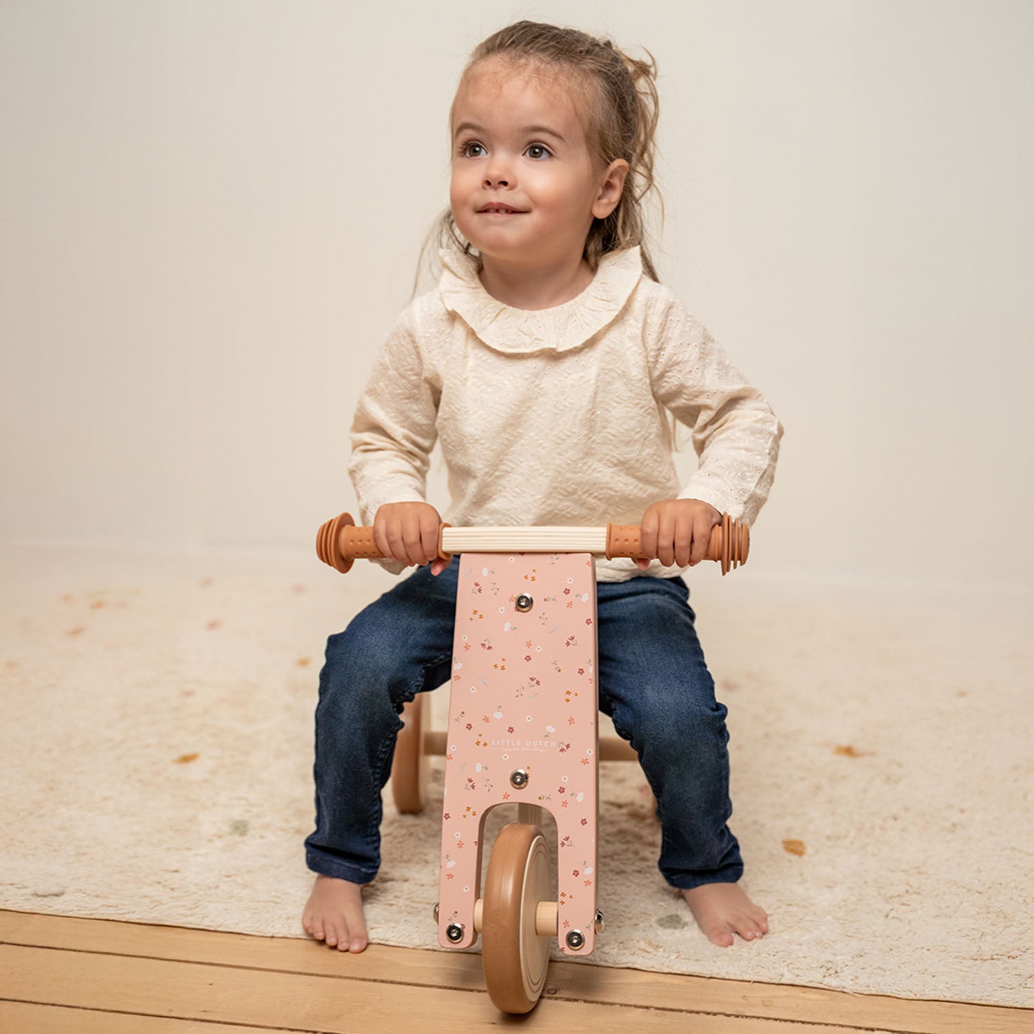 A toddler is riding the Little Dutch triccle in pink colour.