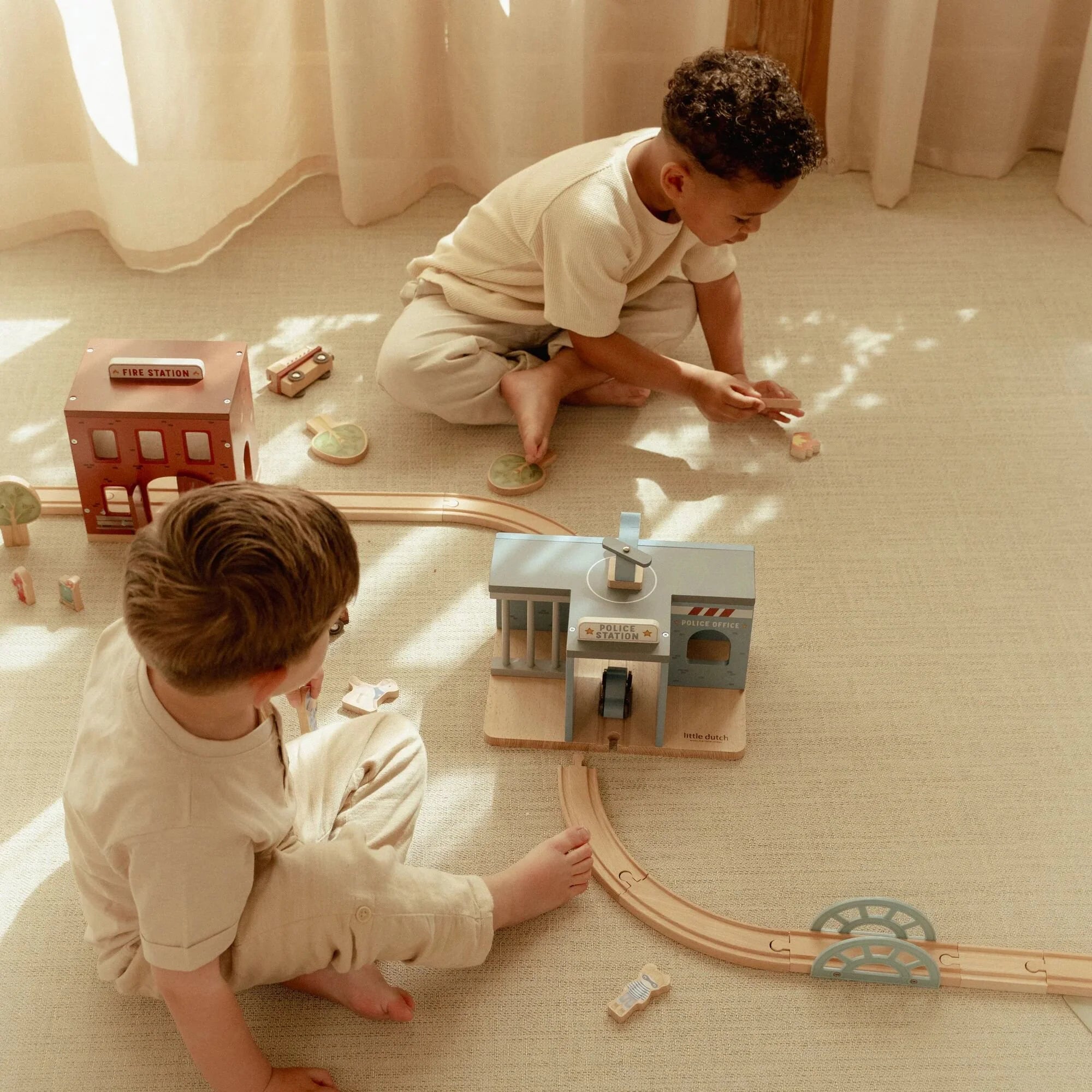 Child playing with Little Dutch fire station toy.