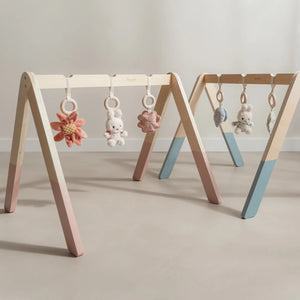 Miffy baby gym in blue with three soft hanging toys on wooden frame.