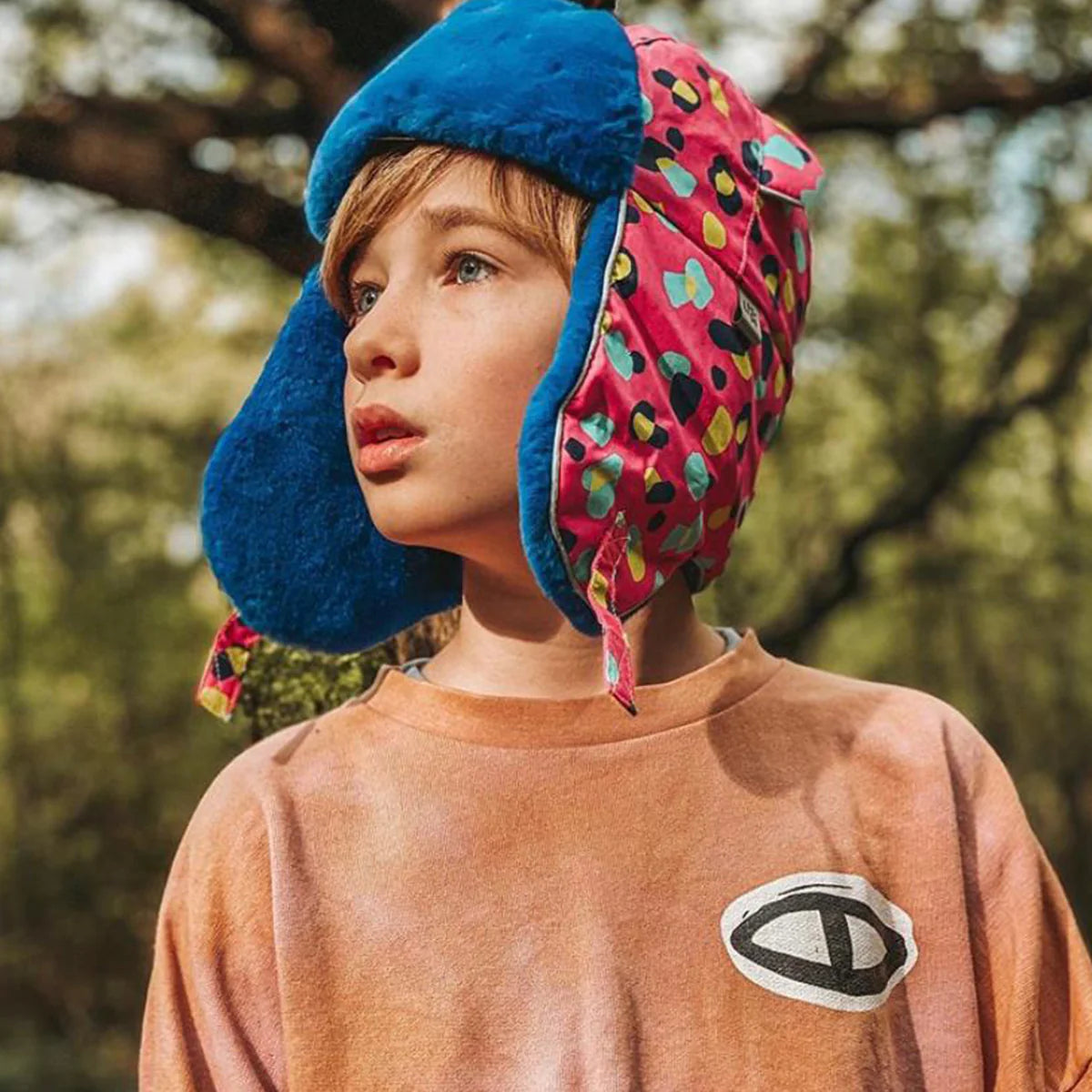 Child wearing colorful earflap hats outdoors