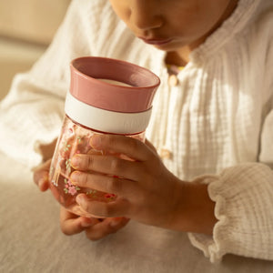 A kid is having water with the little ditch mio drinking cup