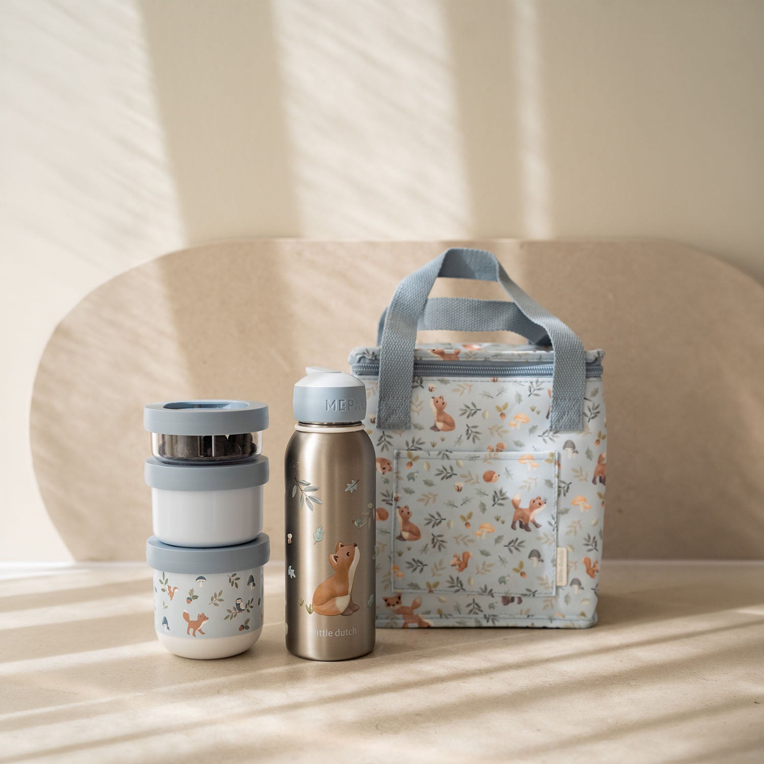 Blue Little Dutch Forest Friends cooler bag sitting next to a matching Mepal water bottle and food jar.