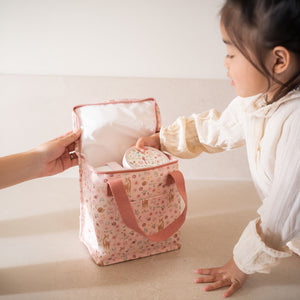 A young child opening a pink Little Dutch Fairy Garden insulated cooler bag.
