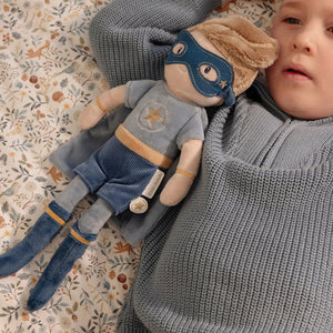 A boy is holding the little dutch superhero jim. 