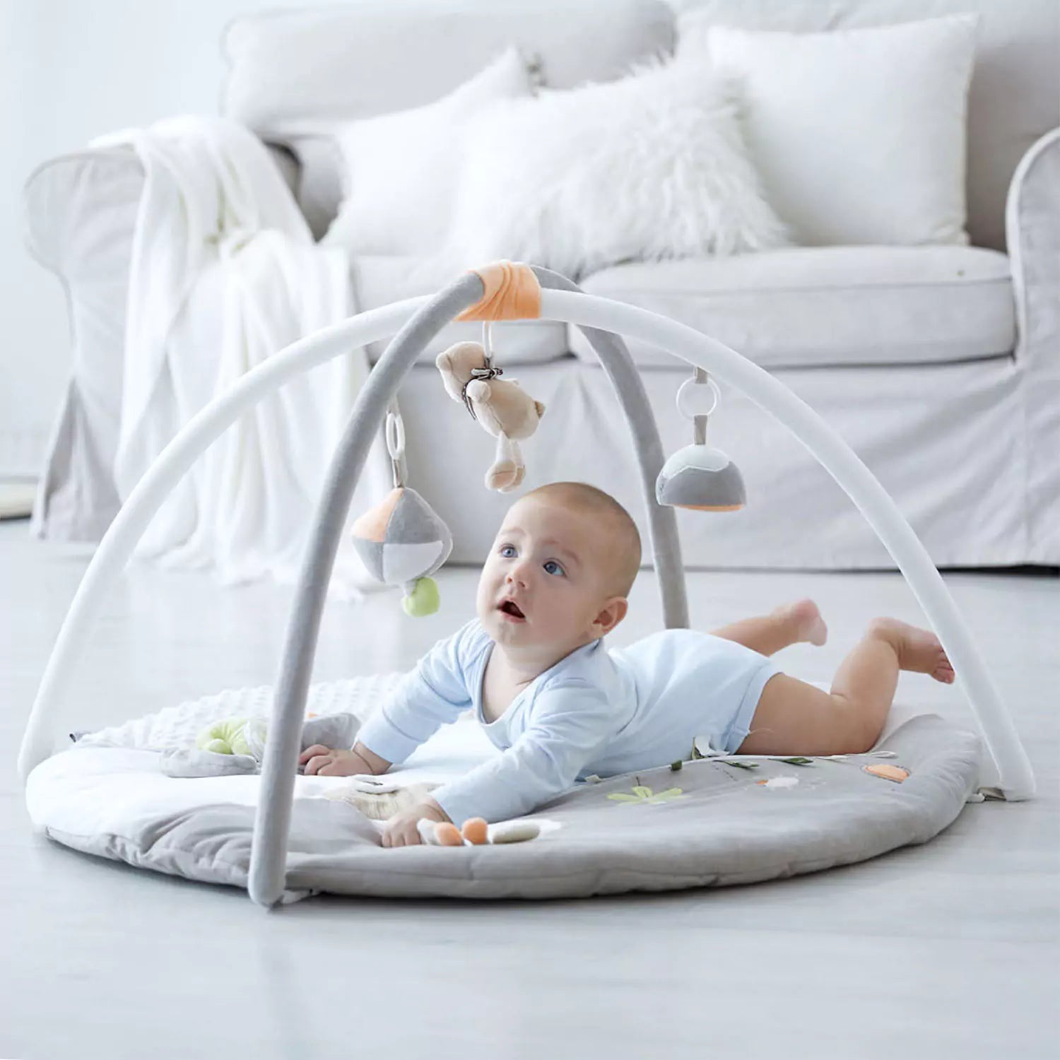 The baby is playing with the Luxury Musical Baby Playmat, which comes with a soft cushioned mat.