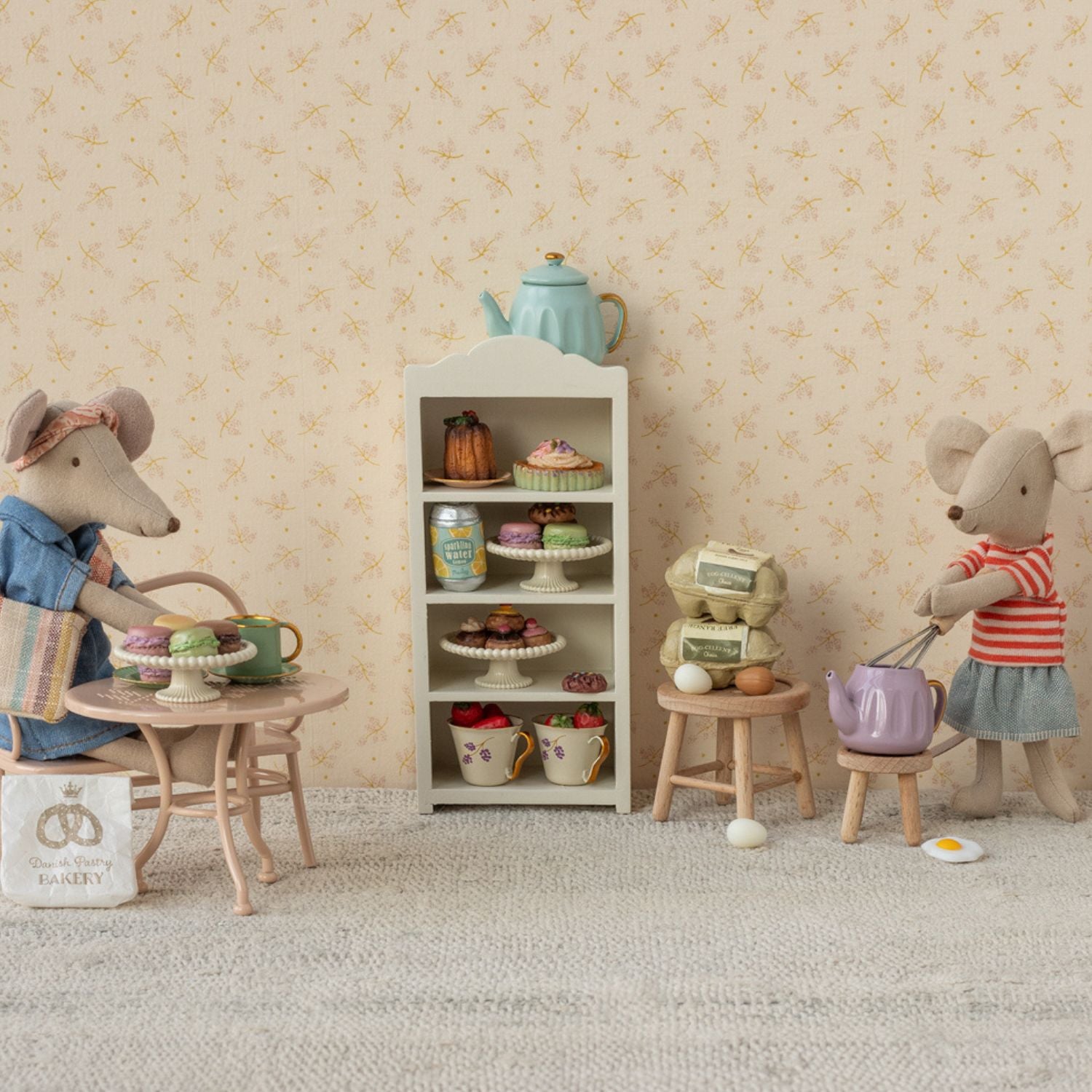 Close-up of Maileg big mouse sitting at pale pink café table.