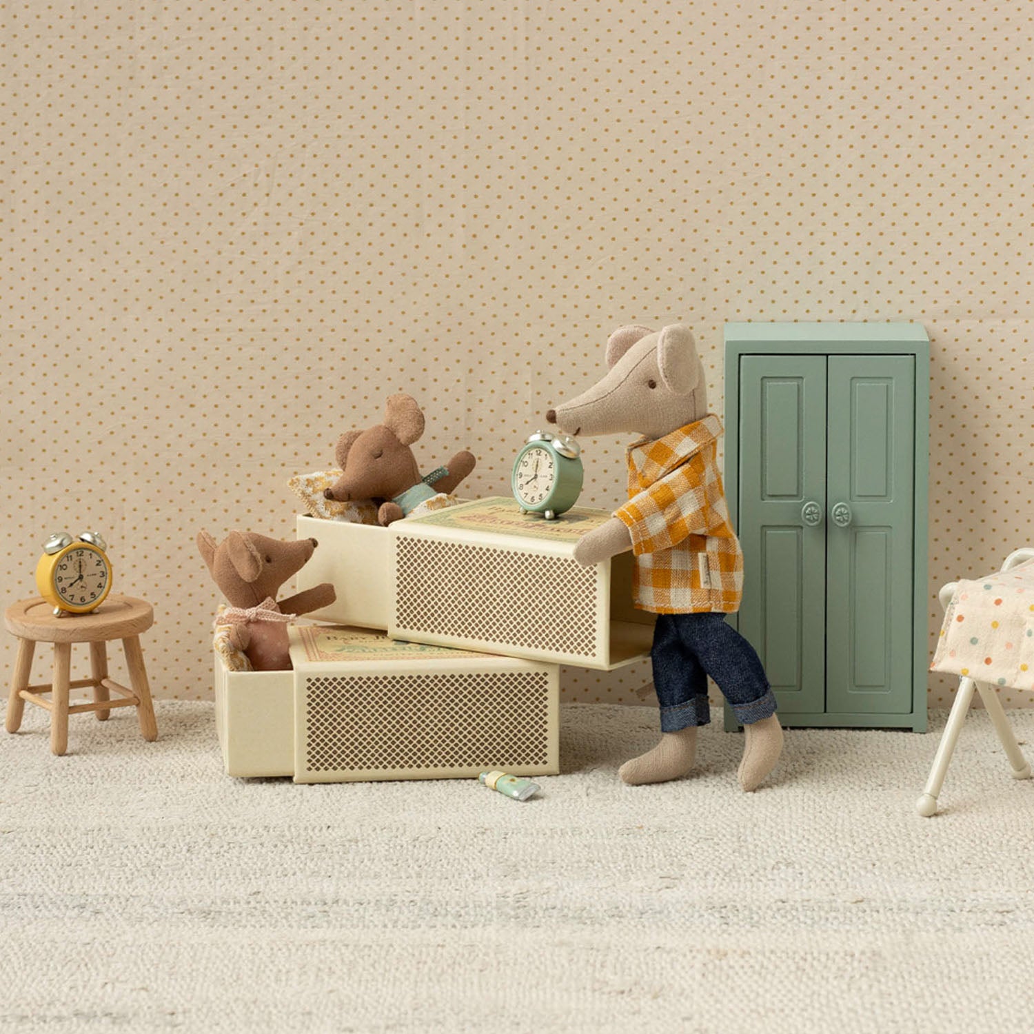 The rose baby mouse and bedding lay flat on a soft, textured knitted blanket in the matchbox.