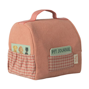 Soft toy puppy carrier with a decorative pet identification tag for imaginative play.