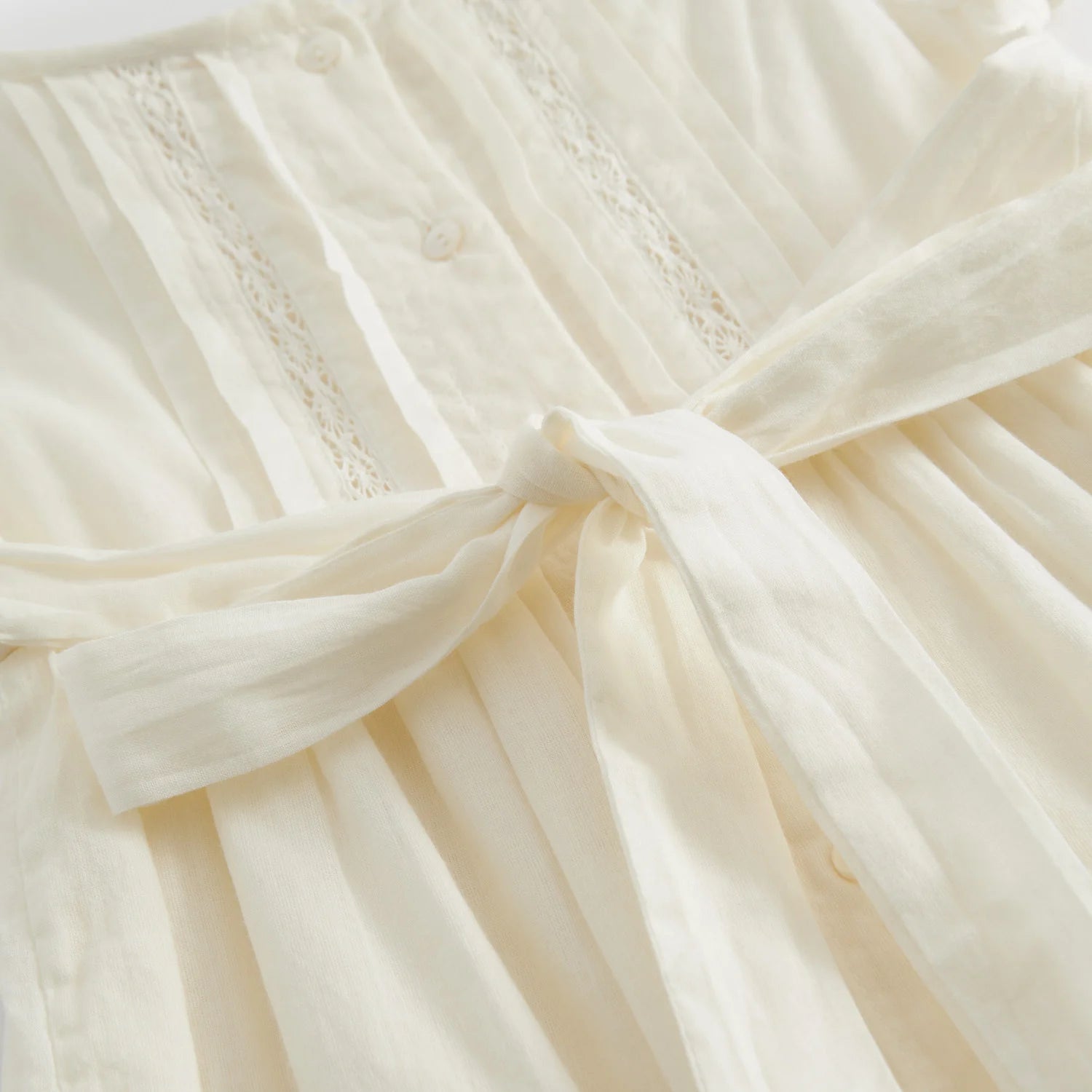 Close-up of delicate fabric and details on Daisa Long Christening Dress.