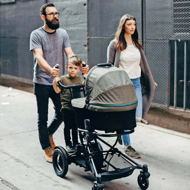 The adaptable Micralite Twofold allows a parent to take a relaxing walk with their toddler on the built-in stroller board and their infant snoozing soundly in the carrycot.
