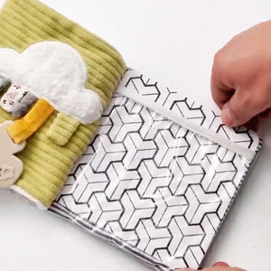 Close-up of hands interacting with the clear pocket and high-contrast black and white patterned textures inside the MiniDream activity book.