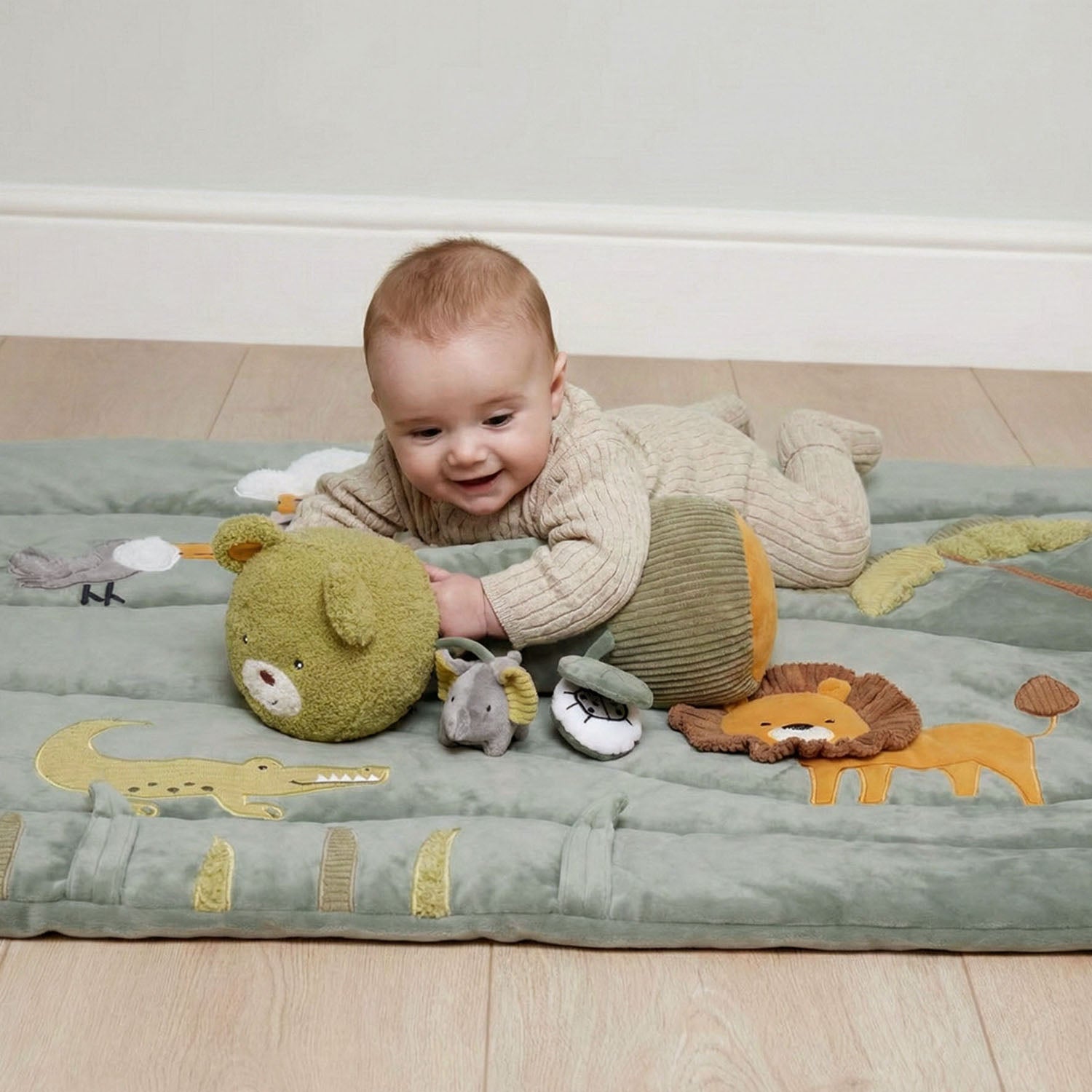 A baby is playing with the tummy time roller.