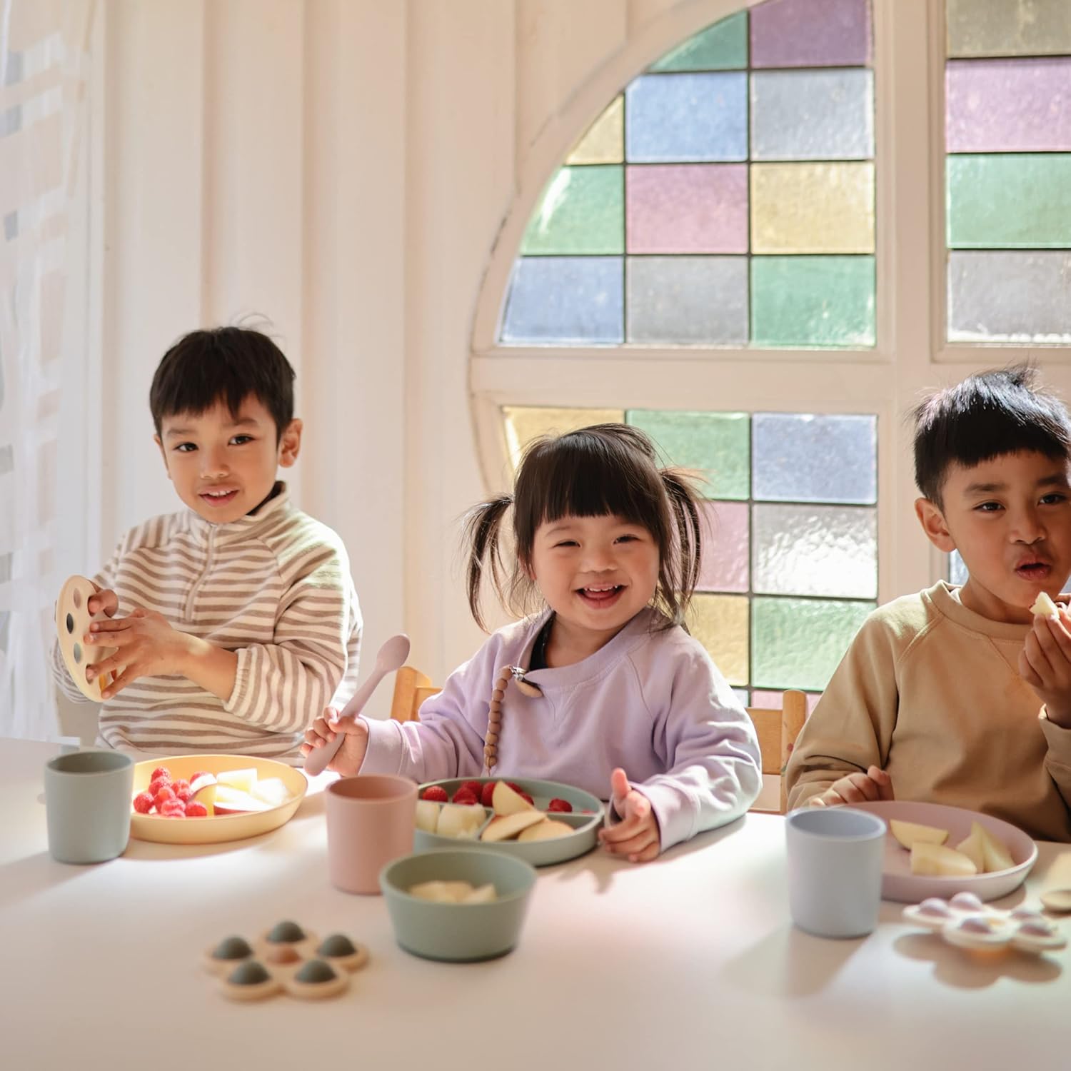 Kids are having fun while eating food with the Mushie dinnerware fork and spoon.