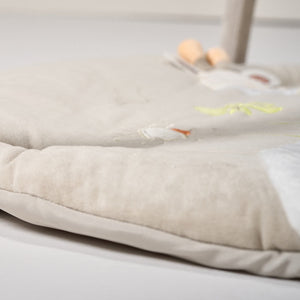 Close-up of a textured fabric surface with embroidered designs on a light gray background