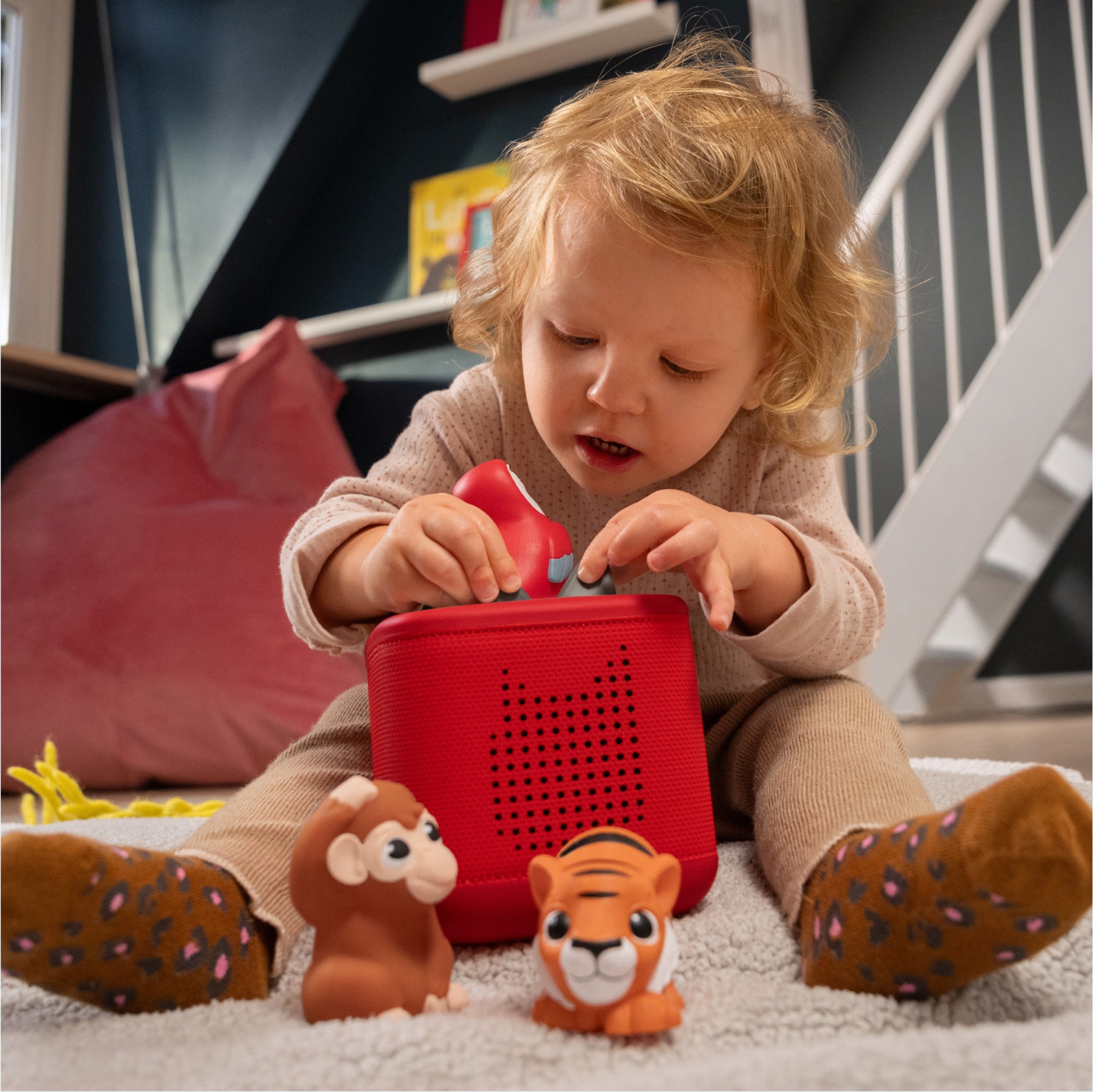 A kid is listening to jungle animal sounds with Toniebox and Jungle Set