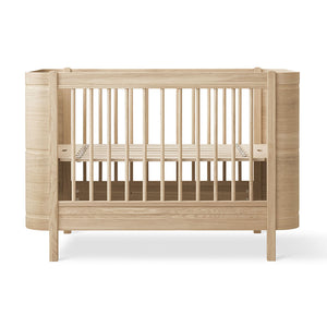 Oliver Furniture Wood Mini+ Cot Bed with natural wood tone.