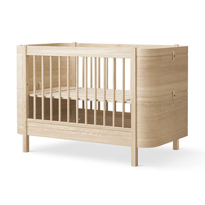 Modern minimalist cot bed in oak with smooth finish.