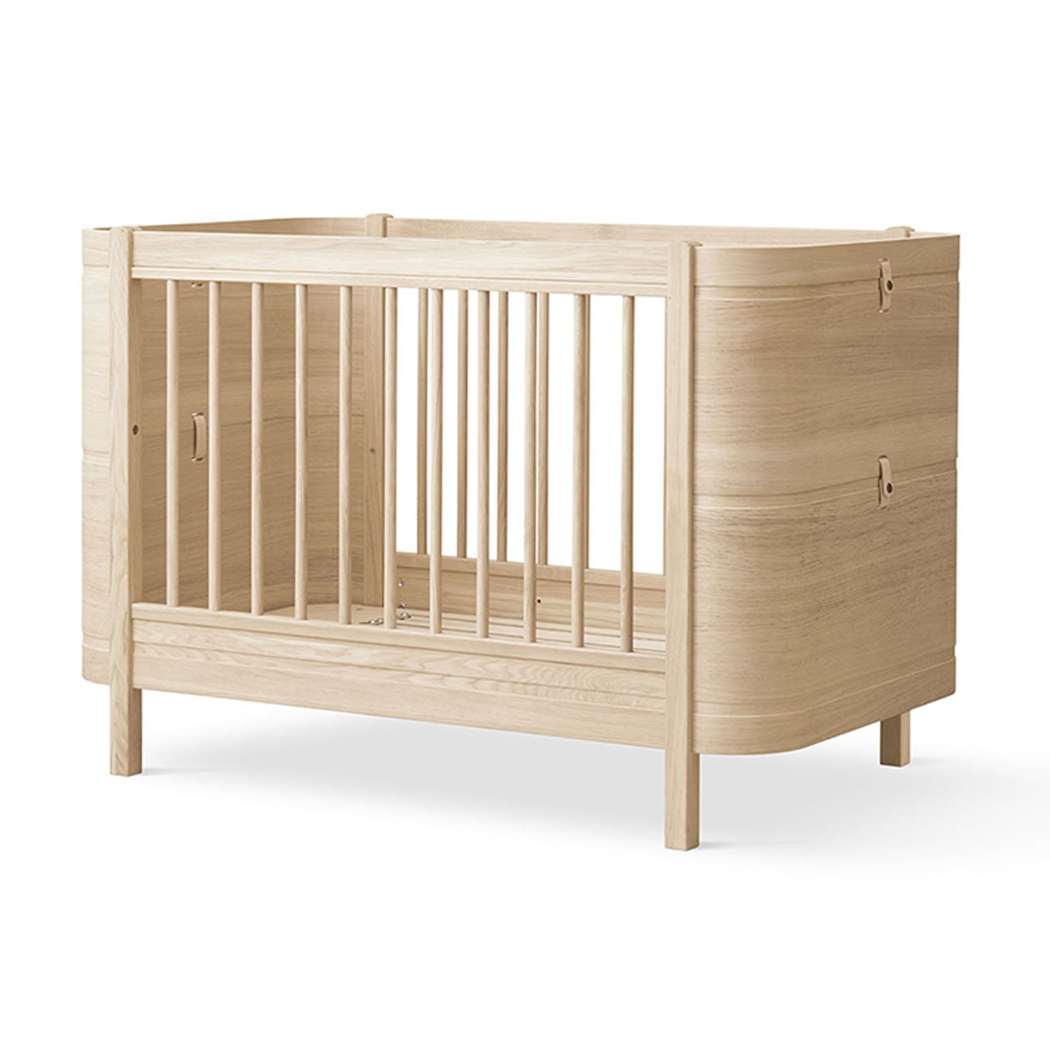 Compact oak cot bed perfect for modern nursery interiors.