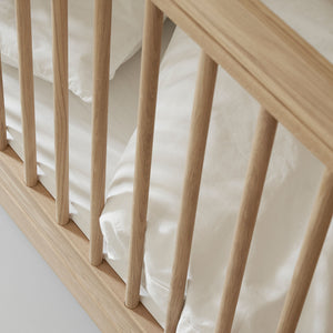 Baby cot with adjustable mattress base and removable bars.