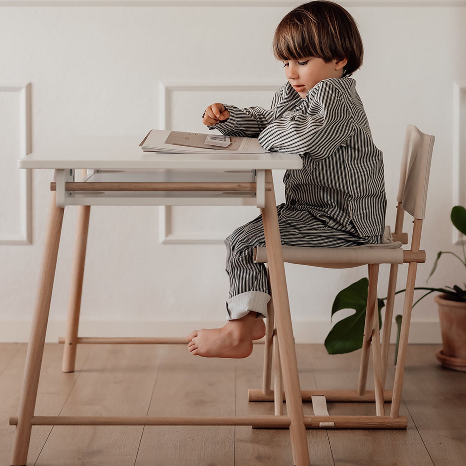 Adjustable kids desk with storage shelf and side sticks.