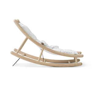 Calm Scandinavian baby rocker designed with gentle curves and natural wood tones