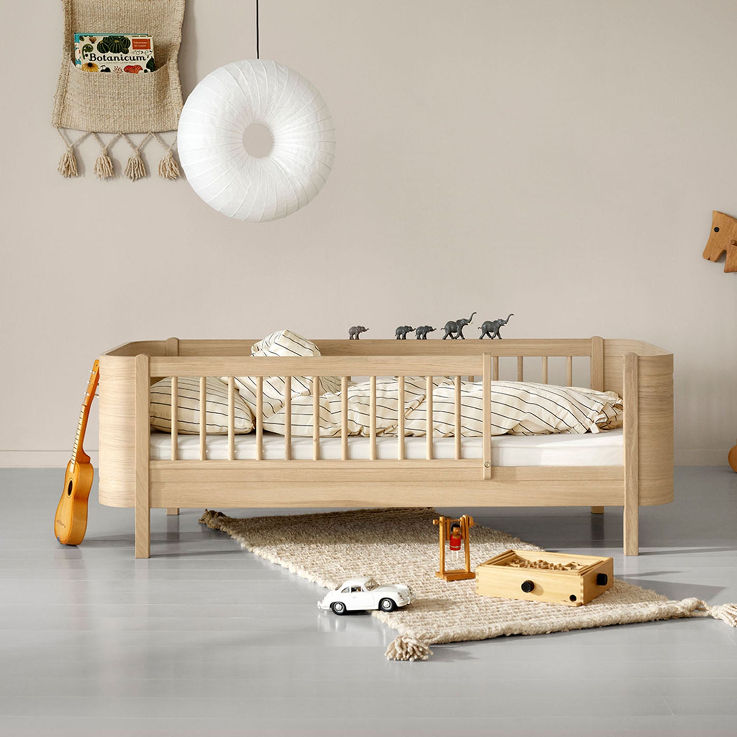 Wooden crib in a room with toys and decor