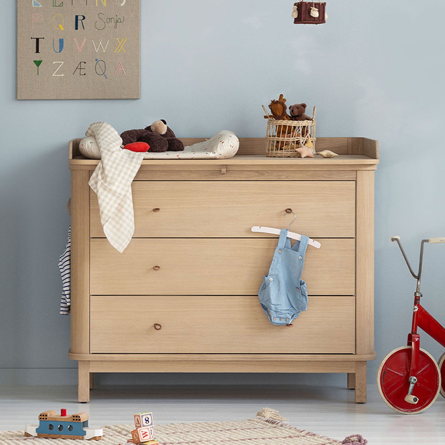 Nursery dresser with changing top and rounded edges in a modern baby room