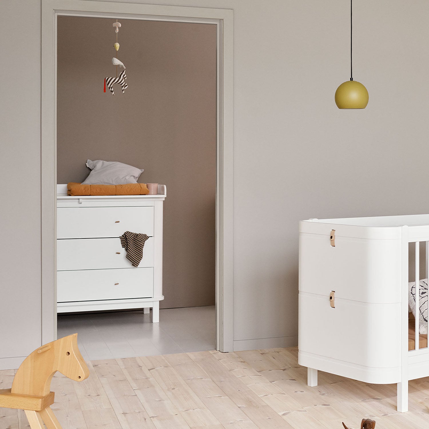 Wide shot of full nursery furniture set with matching wooden tones