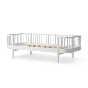 White crib with wooden slats on a white background