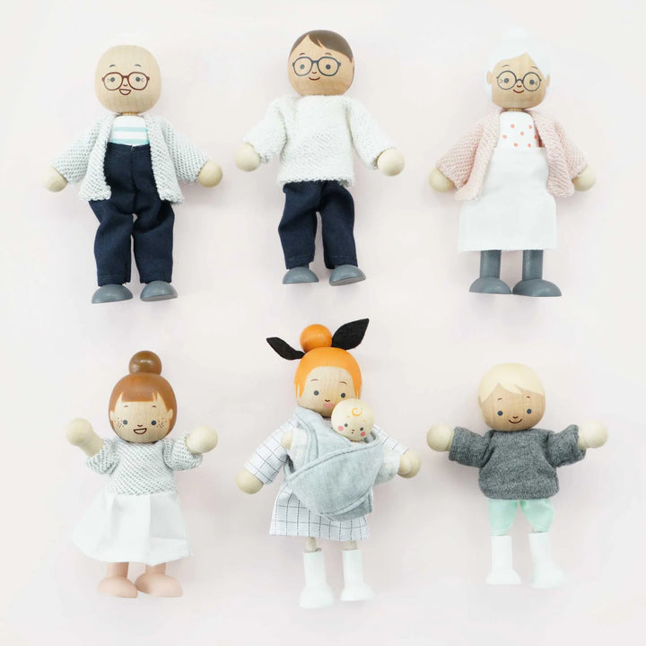wooden doll house family figures pink background