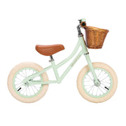Children's balance bike with a wicker basket on a white background