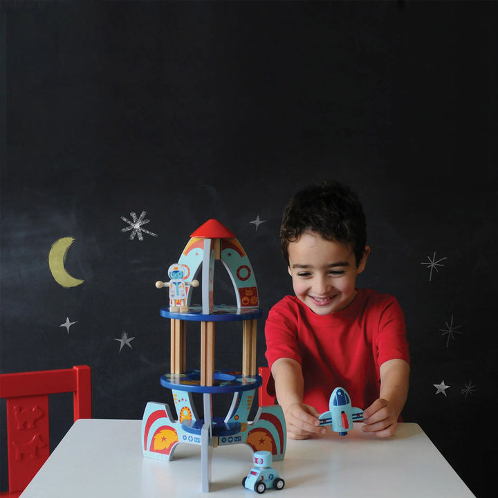 Child building a wooden rocket ship toy with simple connectors
