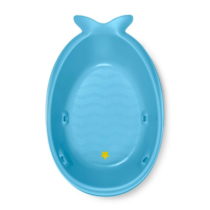 Close-up of the blue Skip Hop Moby 3-Stage Bathtub's non-slip texture and convenient drain plug.
