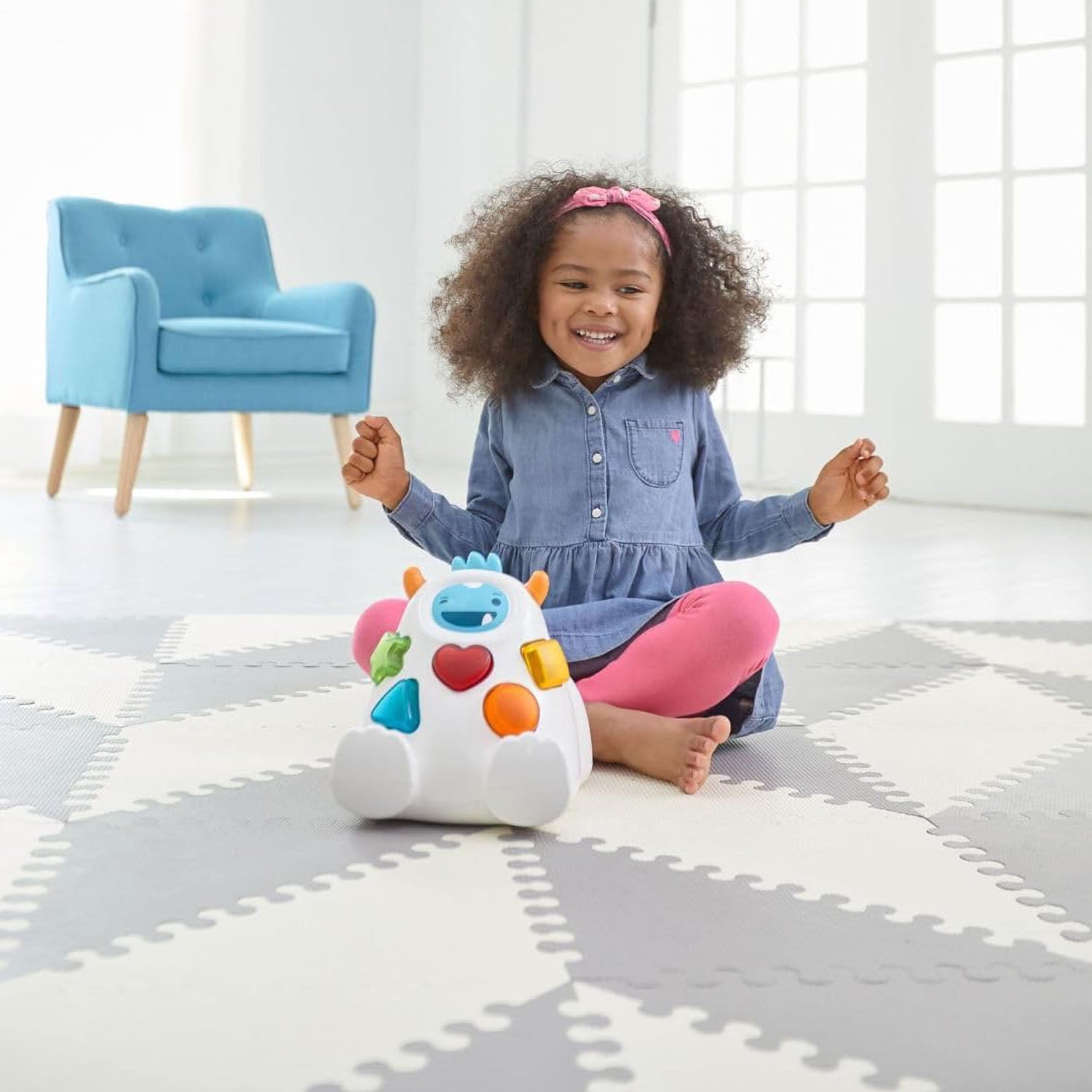 Skip Hop Playspot Geo foam floor tiles arranged in a stylish geometric pattern on a living room floor.
