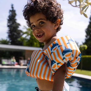 A kid is enjoy summer in the pool.