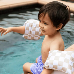 A toddler is having fun in the pool.