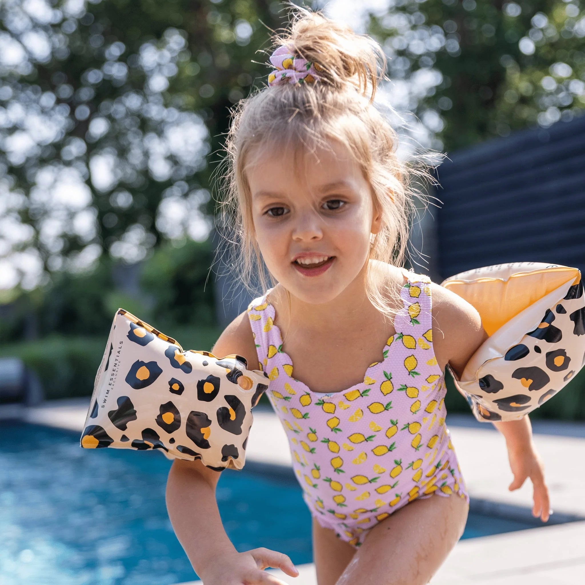 A girl is having fun in the pool wearing the swim essentials armband