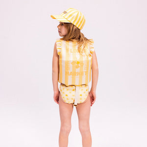 A young child wearing the floral swim vest.