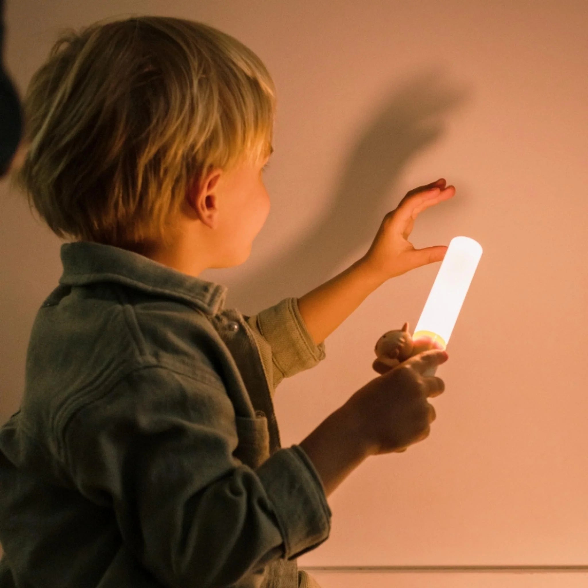 Child holding a glowing stick against a plain background