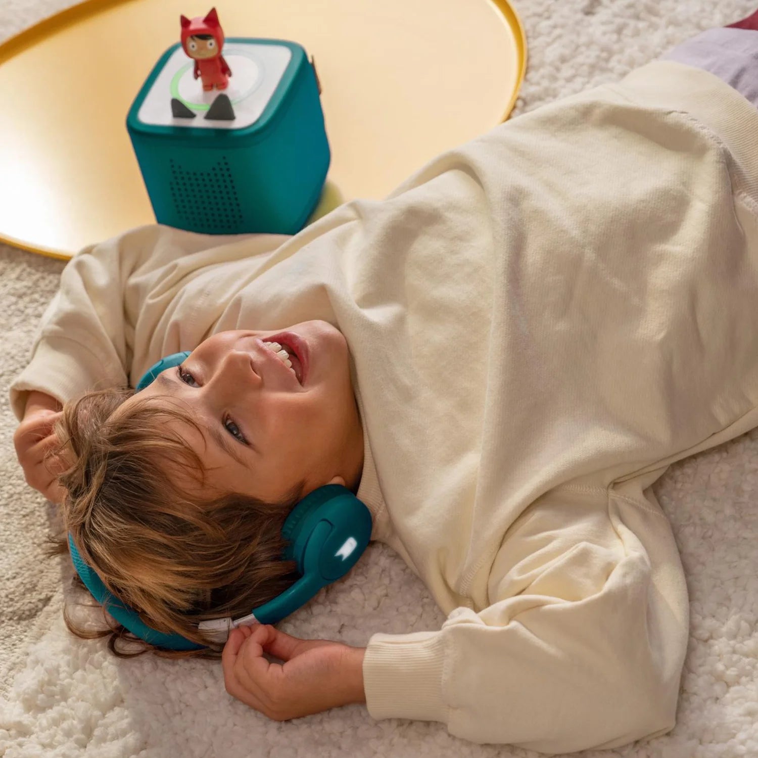 Child smiling while wearing the adjustable wireless headphones.