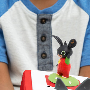 A happy toddler listening to stories of bing bunny tonie.