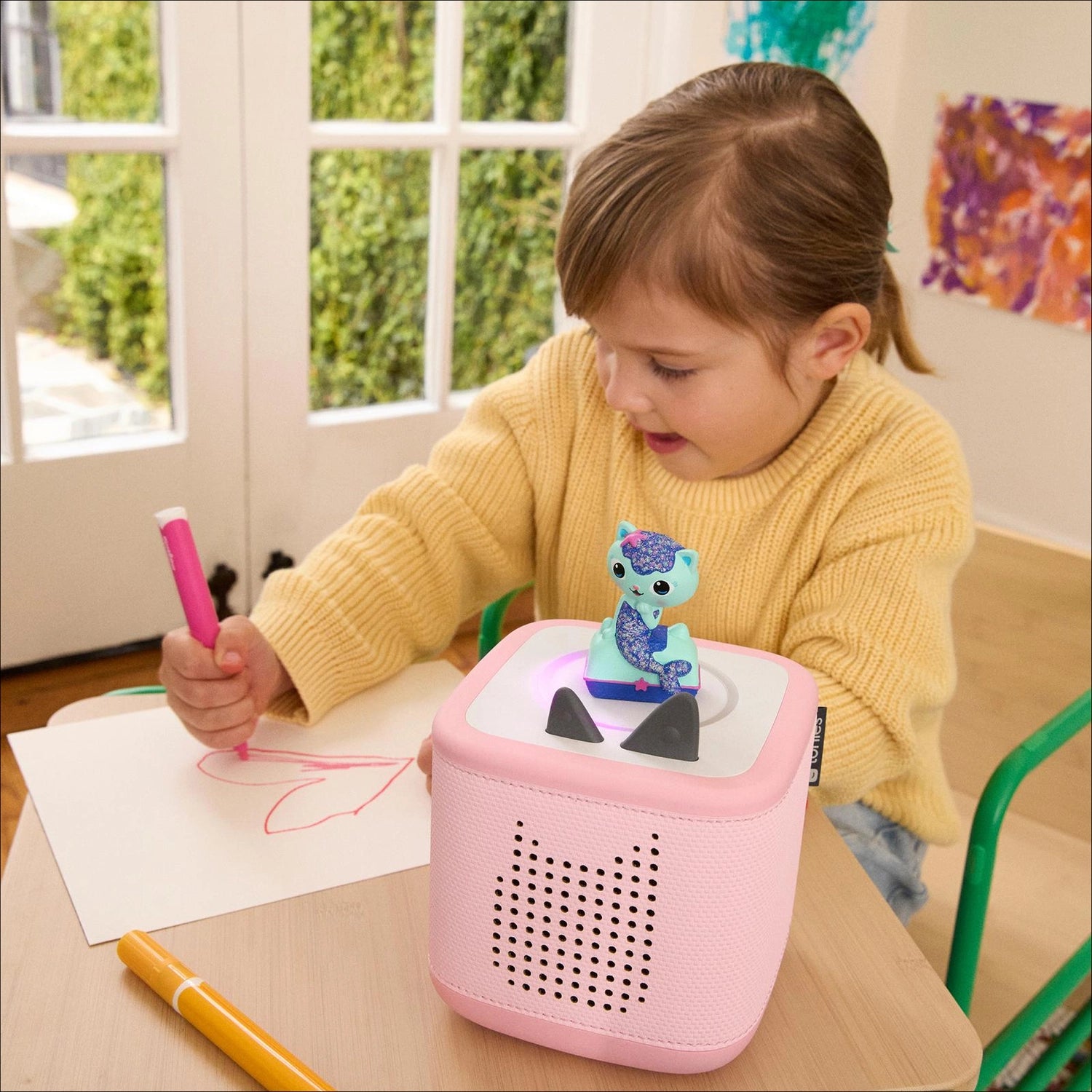 Child listening to mercat tonie adventures on cloud pink toniebox.