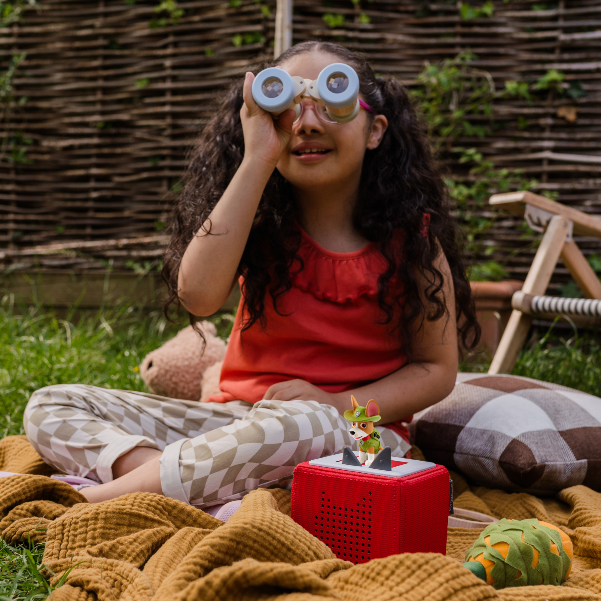 Child listening to the Toniebox with the Tracker audio figure placed on top.